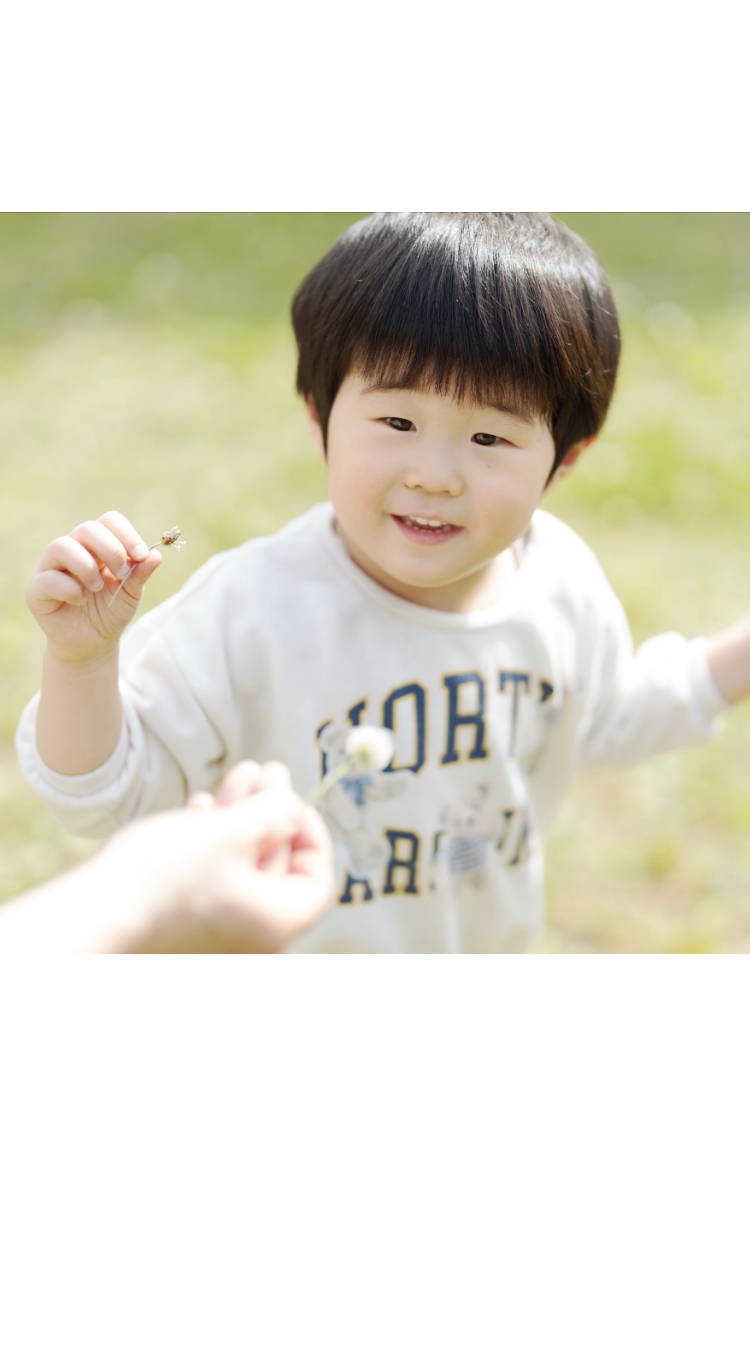 職員が子供にたんぽぽを手渡す様子